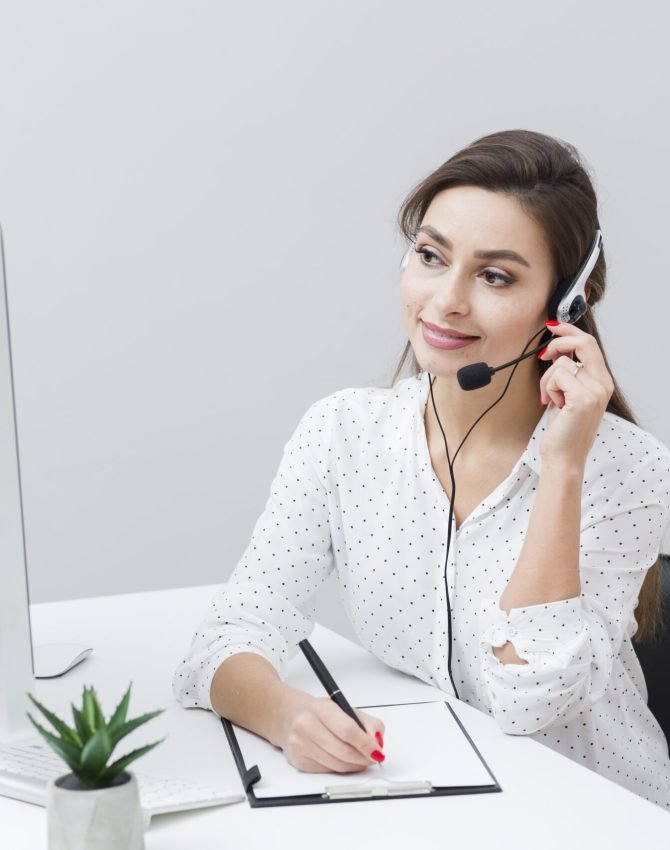 front-view-smiley-woman-writing-something-down-while-talking-headset